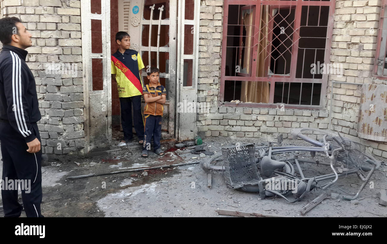 fallujah-iraq-26th-mar-2015-people-stand-by-a-damaged-house-after-EJGJX2.jpg
