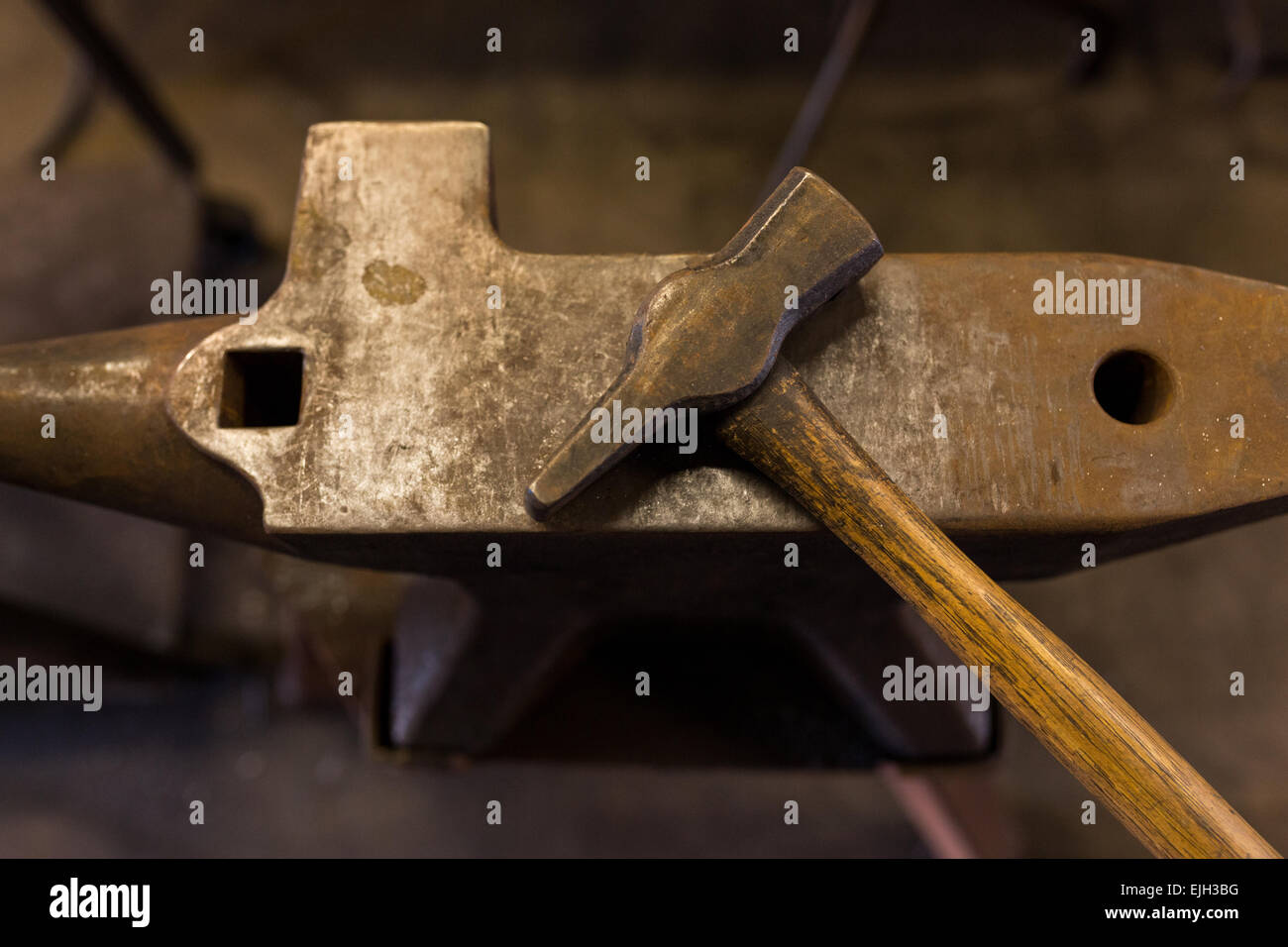 A blacksmith anvil and sledgehammer at a iron working shop in Stock