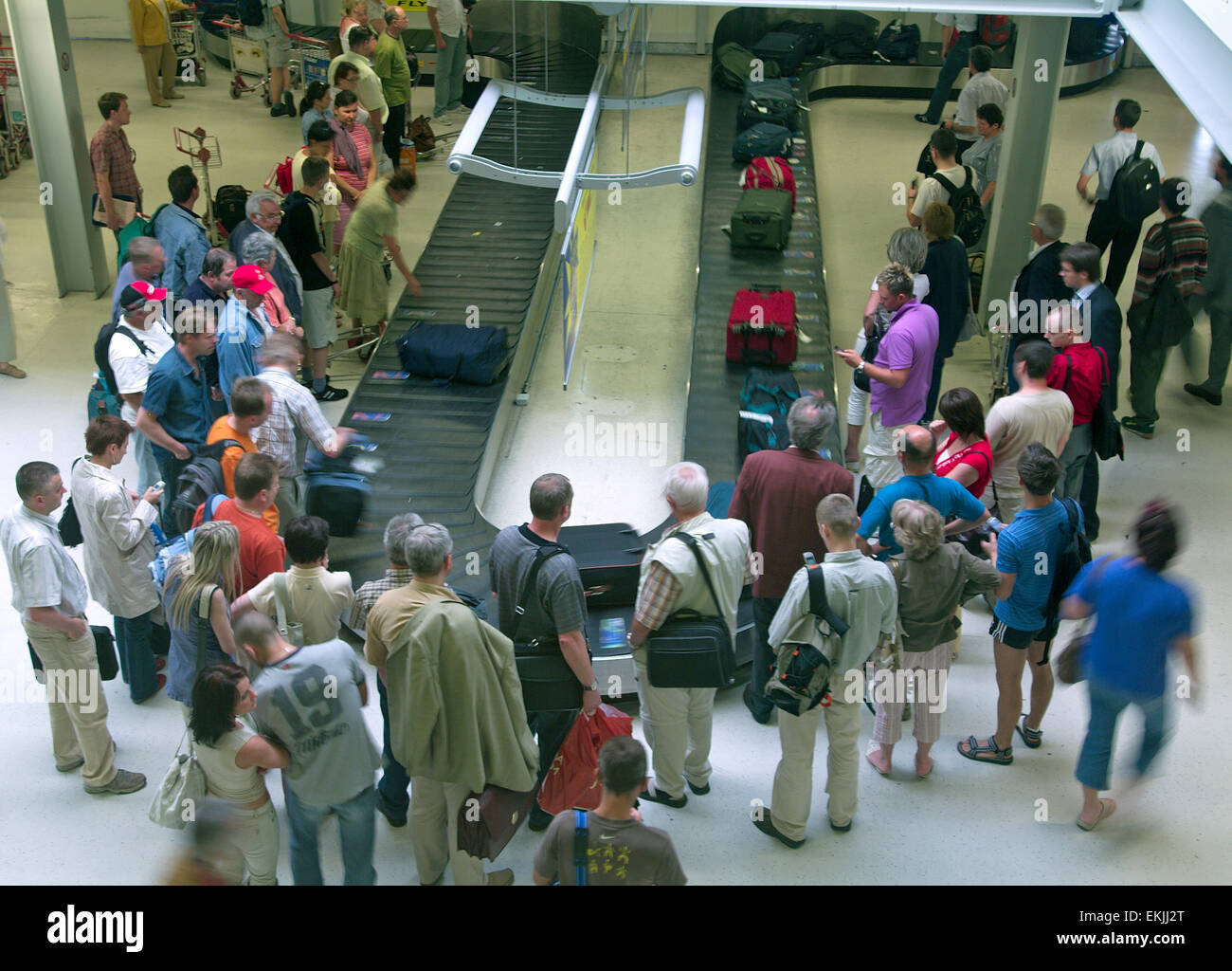 People at the airport waiting for their luggage at the Baggage Stock