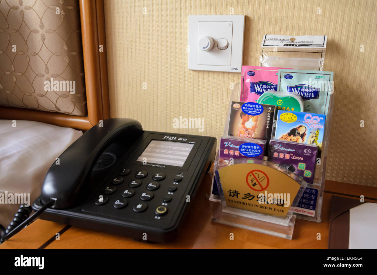 Bedside table of a Chinese hotel telephone, condoms and lube oil