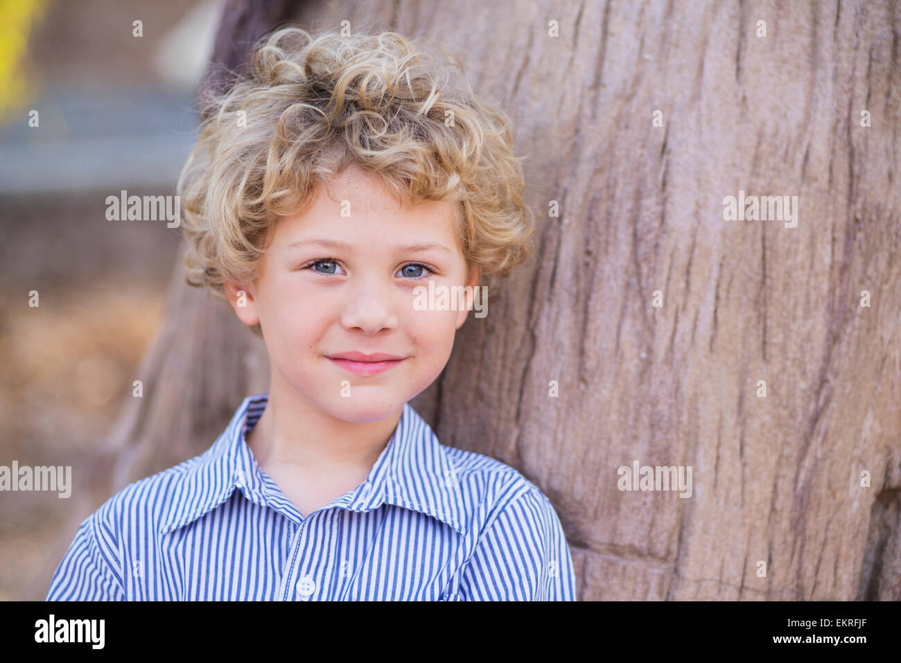 Portrait Of A Young Boy With Blond Curly Hair And Blue Eyes Stock
