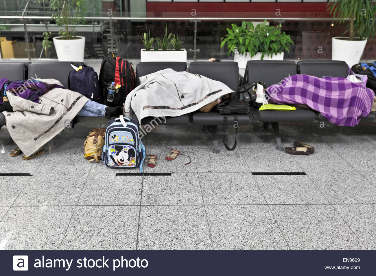 people sleeping on benches at Istanbul Ataturk Airport Turkey Stock