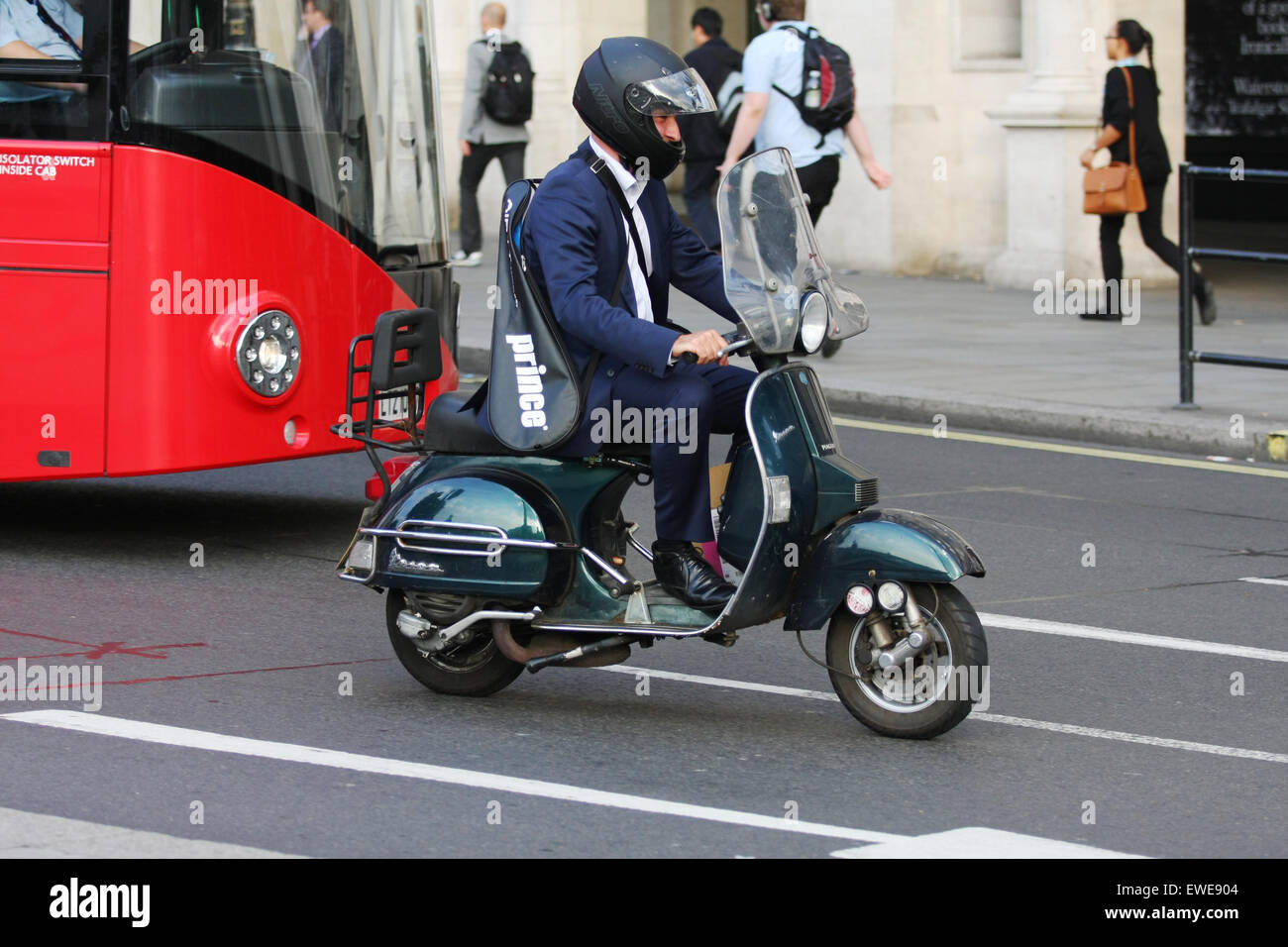 A male riding a motor scooter in traffic, in London, England Stock
