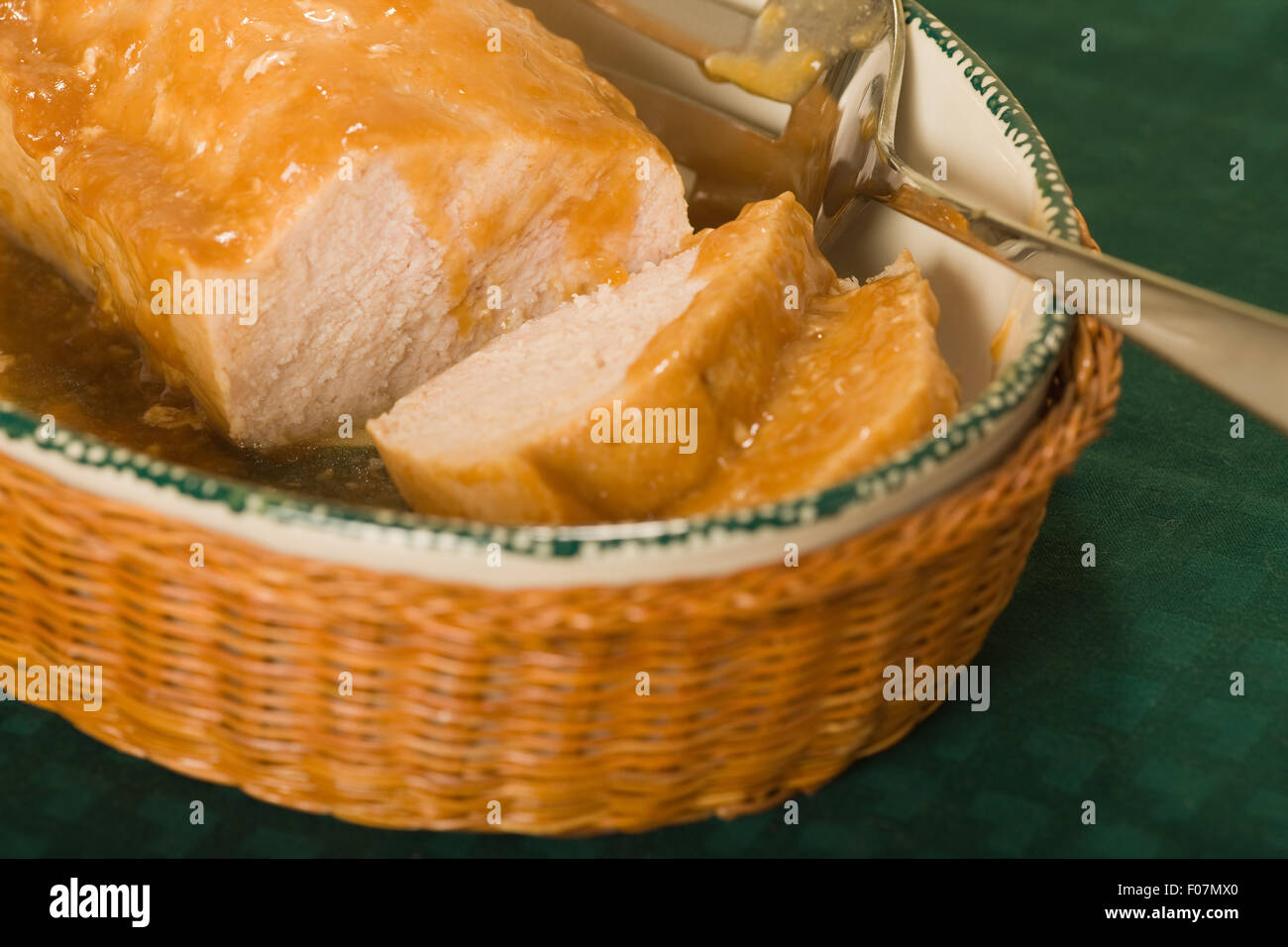 Serving bowl filled with turkey loaf covered by gravy Stock Photo