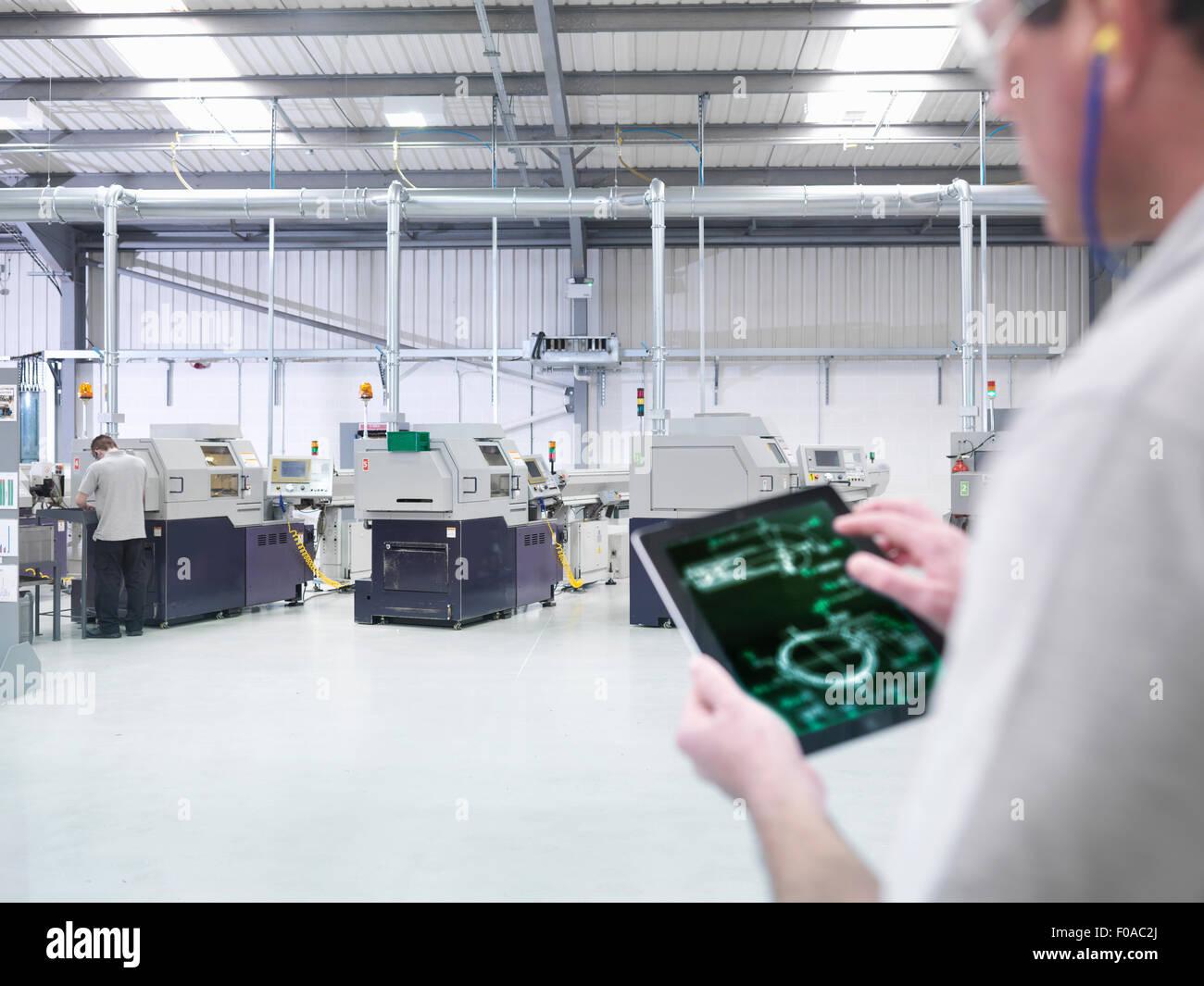 Engineer using digital tablet by production line in factory, close up