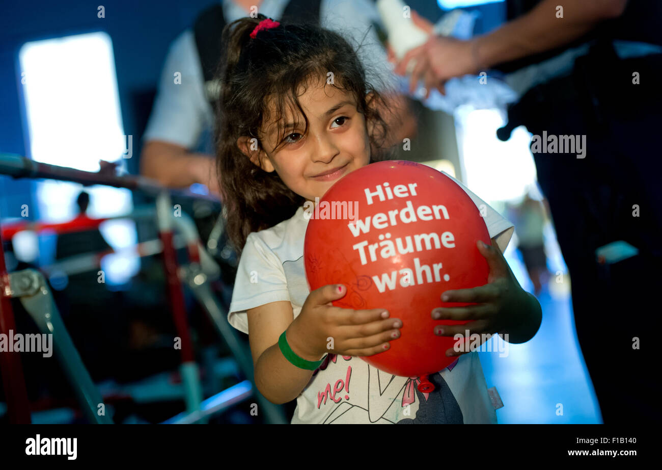 A little refugee girl from Syria holds a red balloon which reads Stock