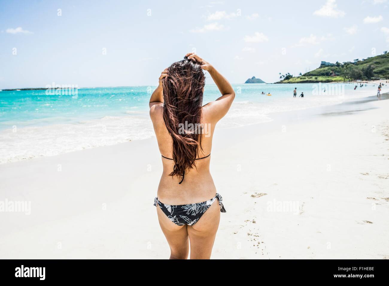 Rear view of young woman wearing bikini on Kailua beach, Oahu Stock