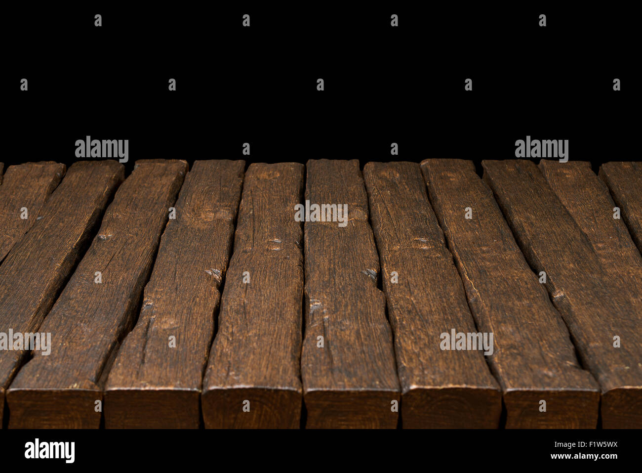 Old rustic wooden table top with solid black background Stock Photo
