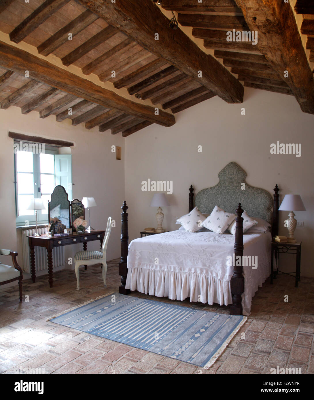 White Bedcover On Bed With Turned Spindles In Italian Country Bedroom Rustic Wooden Beamed Ceiling White Bedcover On Bed With Turned Spindles In Italian Country Bedroom Rustic Wooden Beamed Ceiling