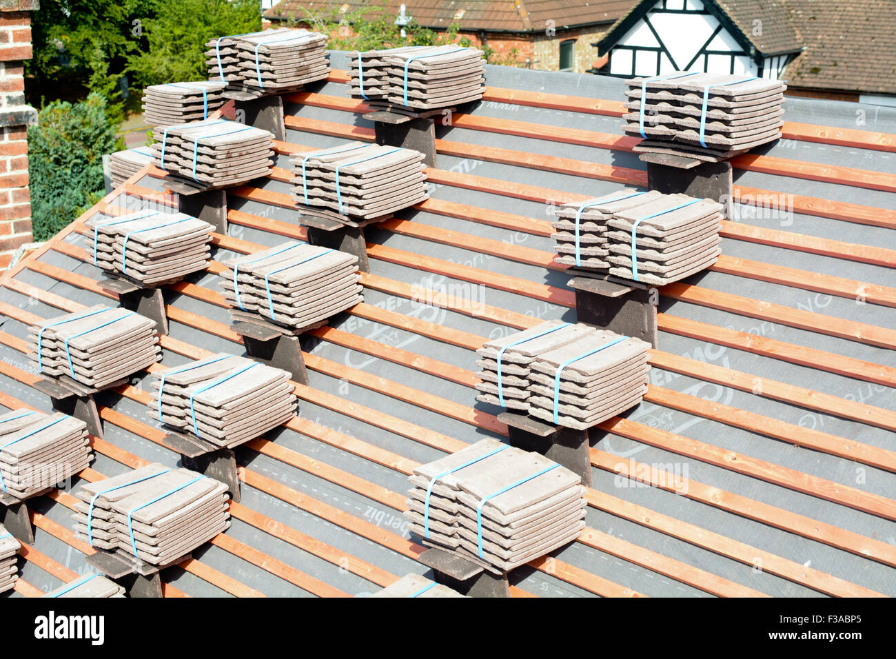 Roof tiles stacked in piles on wooden battens ready for fixing to Stock