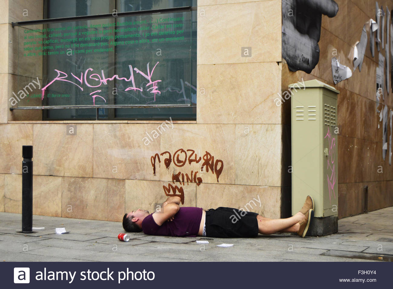 Drunk man sleeping on the pavement in Barcelona Spain Europe Stock