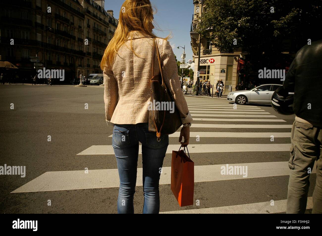 PARIS, FRANCE. PEDESTRIAN CROSSING A BUSY STREET IN