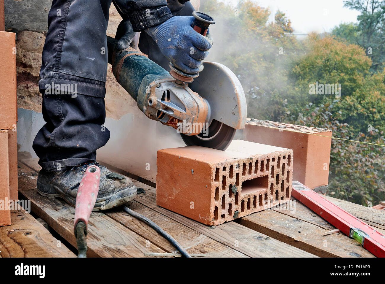 Construction worker using masonry saw to cut concrete blocks to build