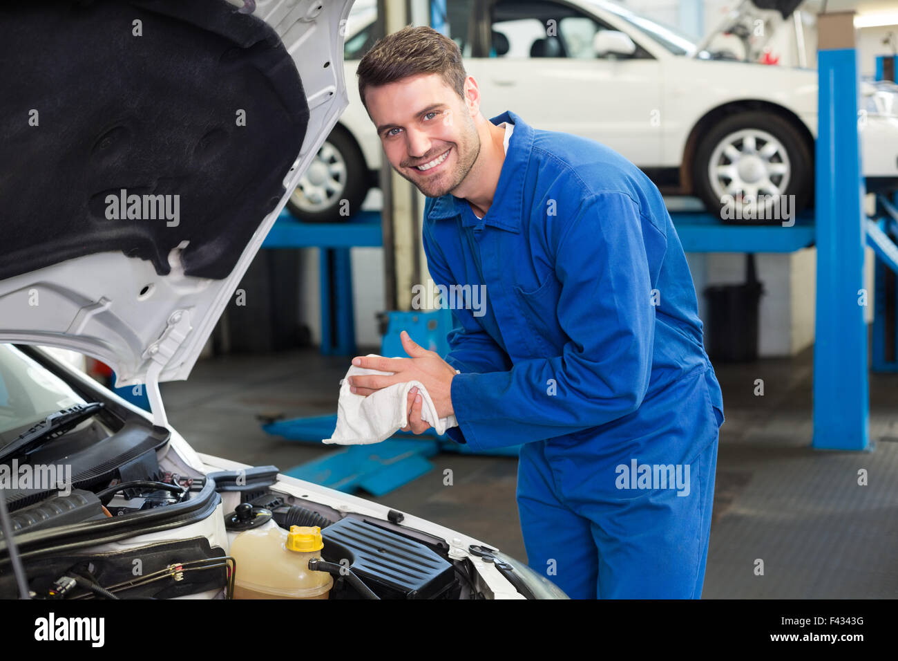 Mechanic examining under hood of car Stock Photo, Royalty Free Image