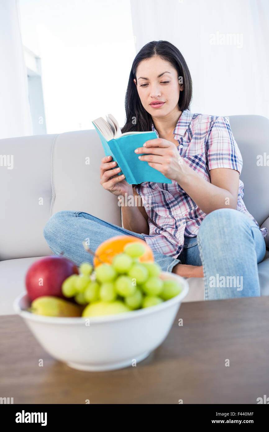 Pretty Brunette Reading A Book On Couch Stock Photo Alamy