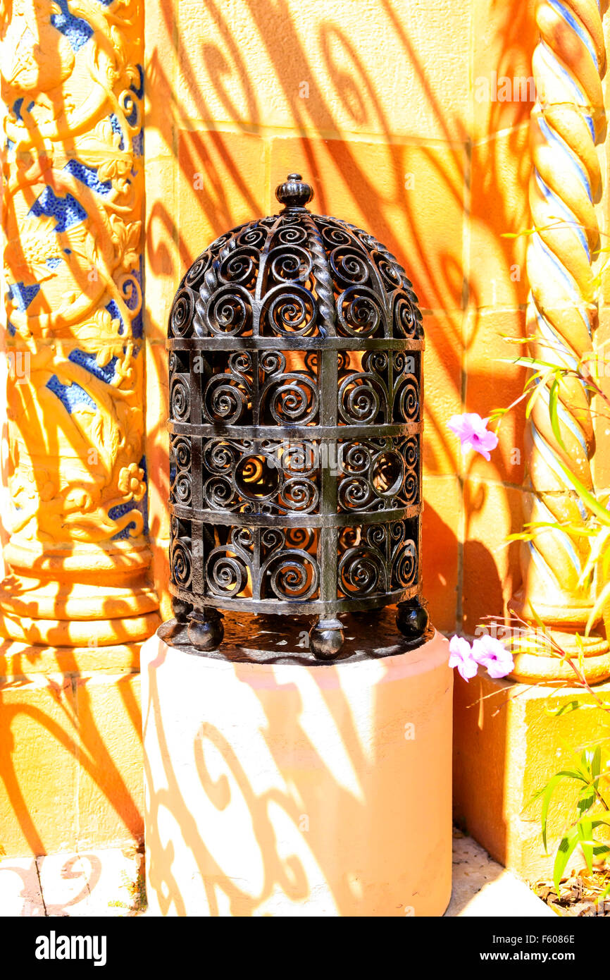 Moroccan lantern in black wrought iron sits in the shadows of a Stock