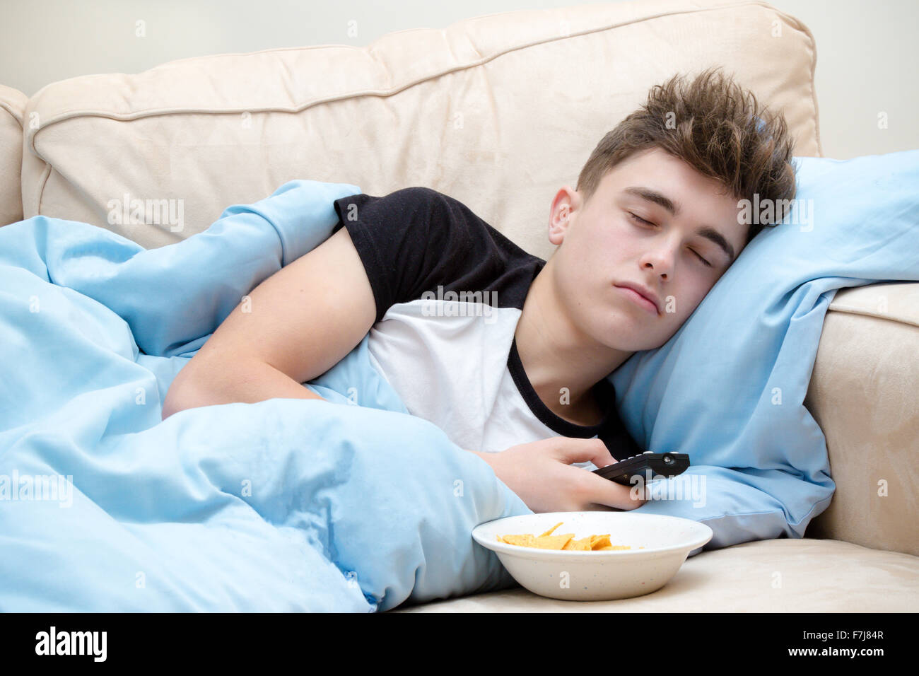 Teenage boy asleep on a sofa Stock Photo, Royalty Free Image 90755975