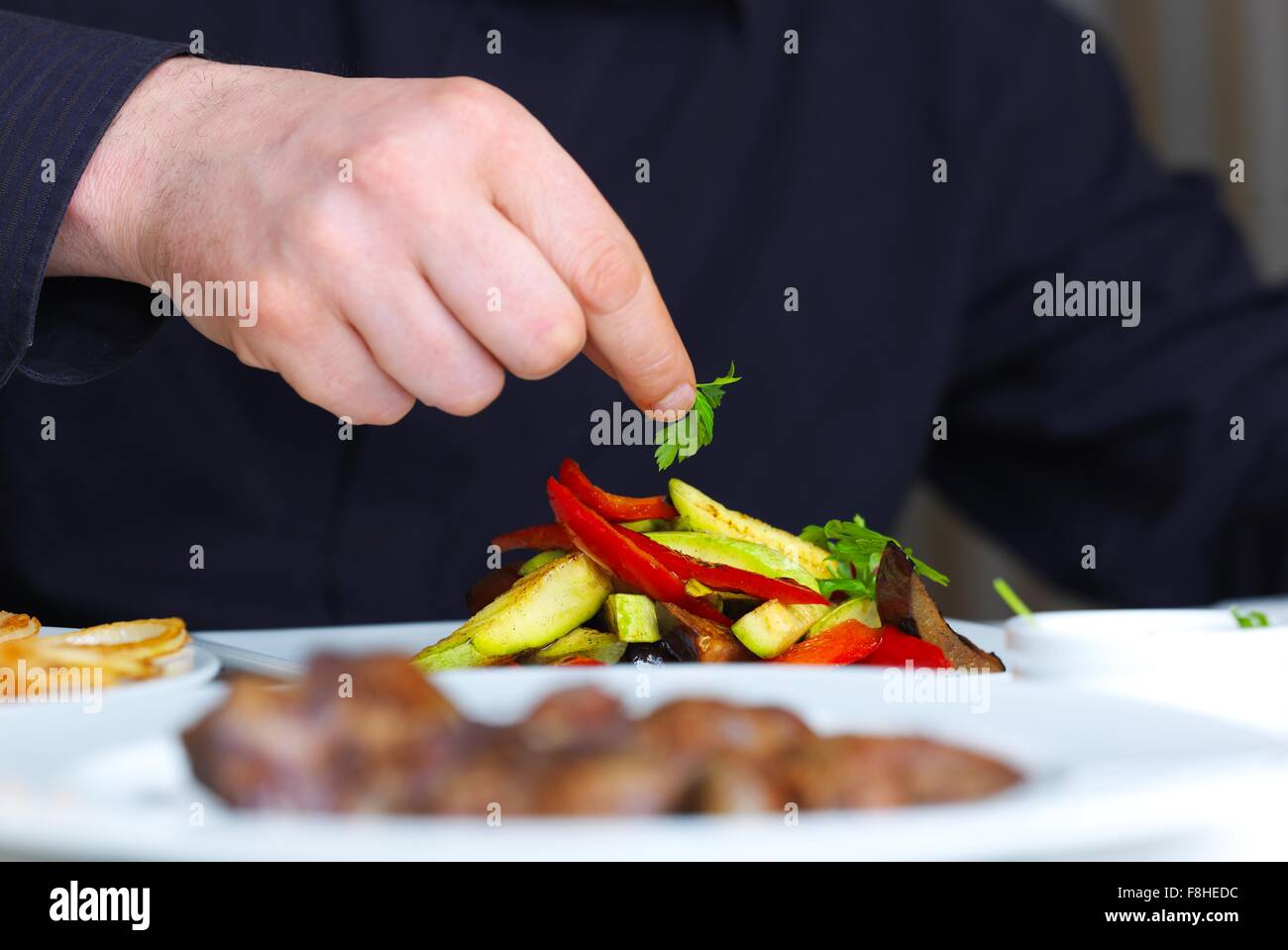 handsome chef dressed in black uniform decorating tasty food in handsome chef dressed in black uniform decorating tasty food in