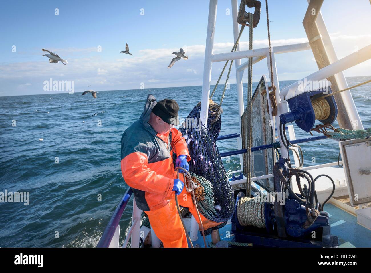 Fisherman preparing nets on trawler Stock Photo, Royalty Free Image