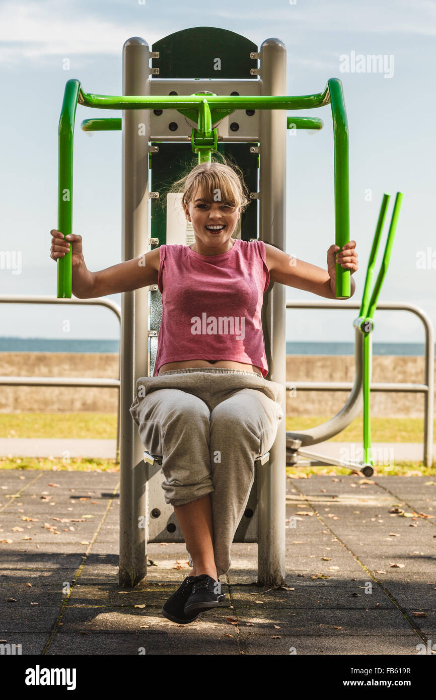 Active Young Woman Exercising On Chest Press Machine Strong Girl In Training Suit Working Out At Outdoor Gym Sport Fitness Active Young Woman Exercising On Chest Press Machine Strong Girl In Training Suit Working Out At Outdoor Gym Sport Fitness