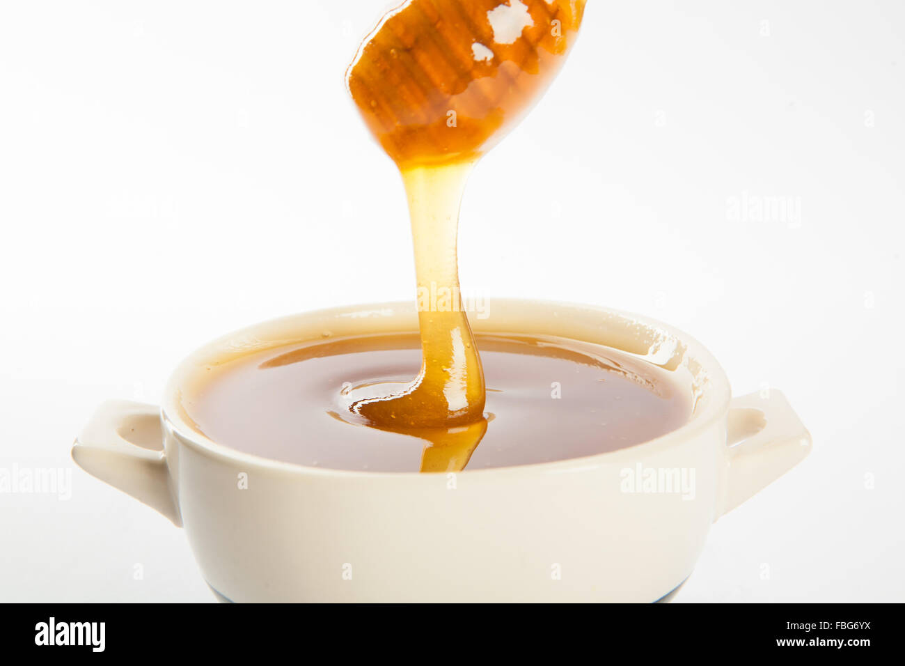 juicy honey in a cup and spoon Stock Photo, Royalty Free Image
