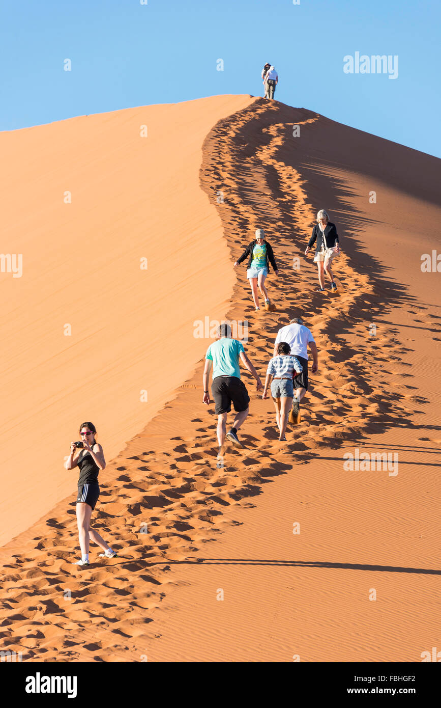 Tourists climbing sand dune, Sossusvlei, Namib Desert, NamibNaukluft