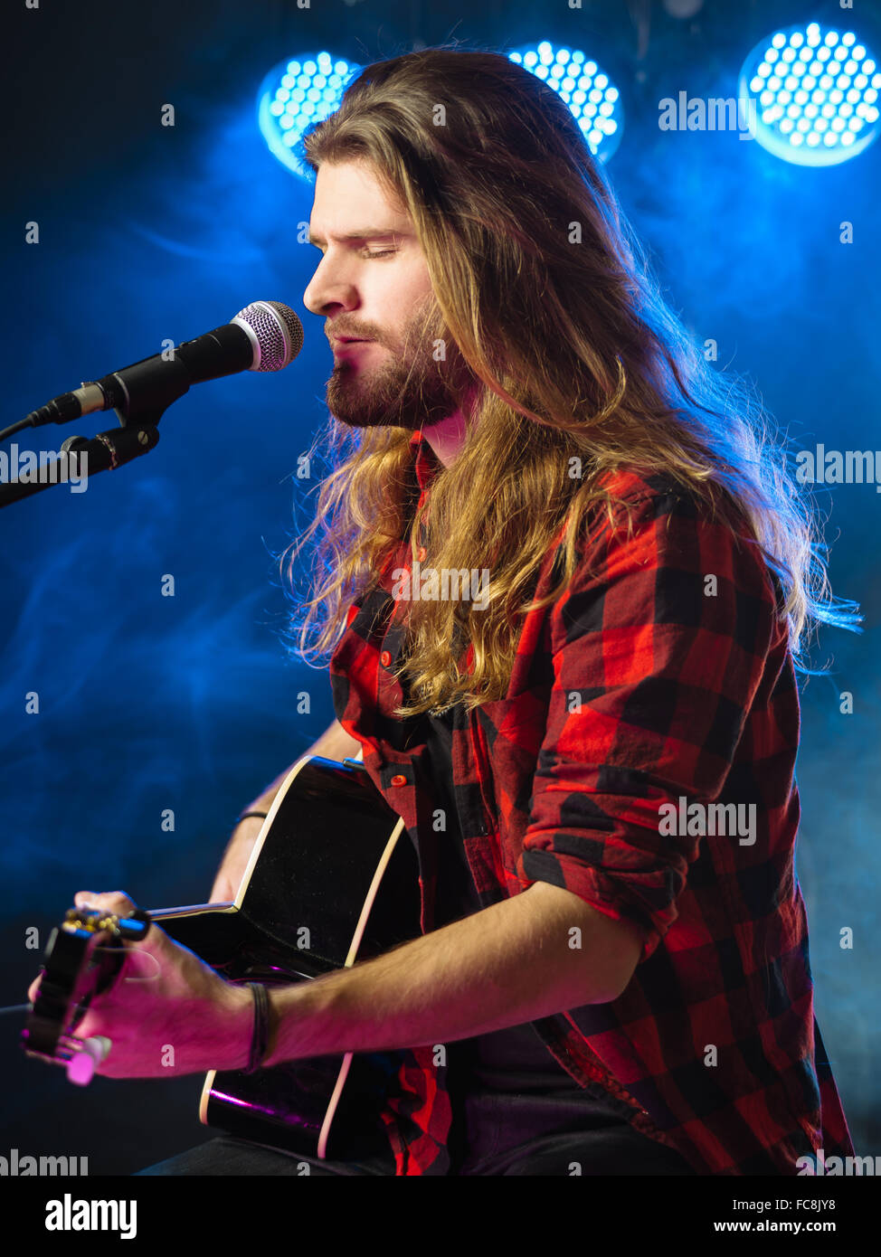 Photo Of A Young Man With Long Hair And A Beard Singing And