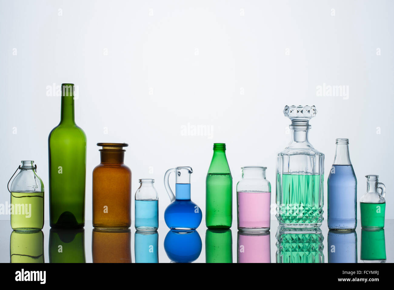 Different types of glass bottles arranged in a row Stock Photo, Royalty