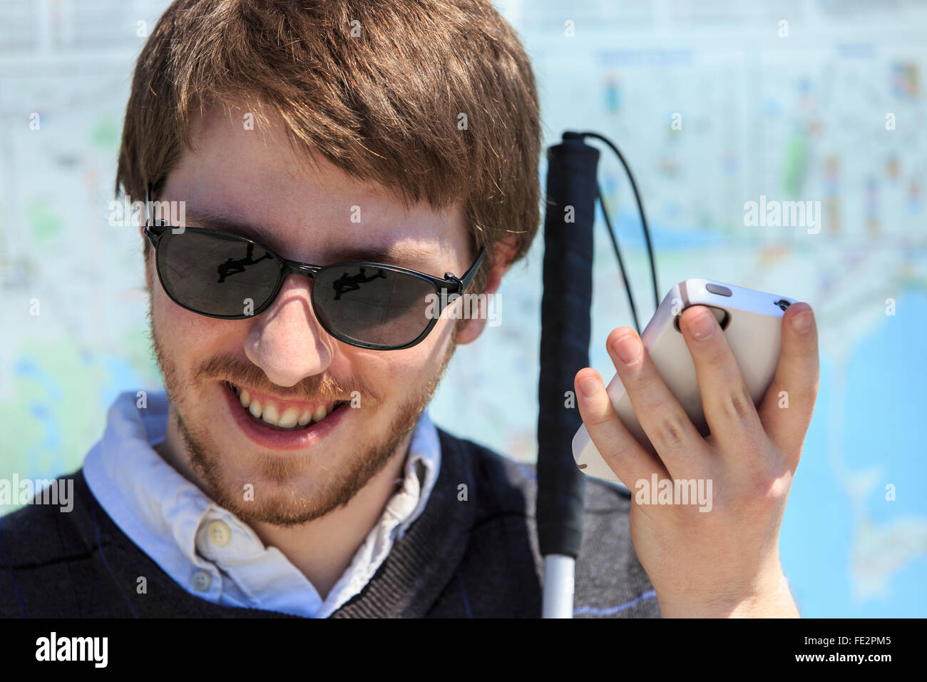 Young blind man with cane using assistive technology Stock Photo
