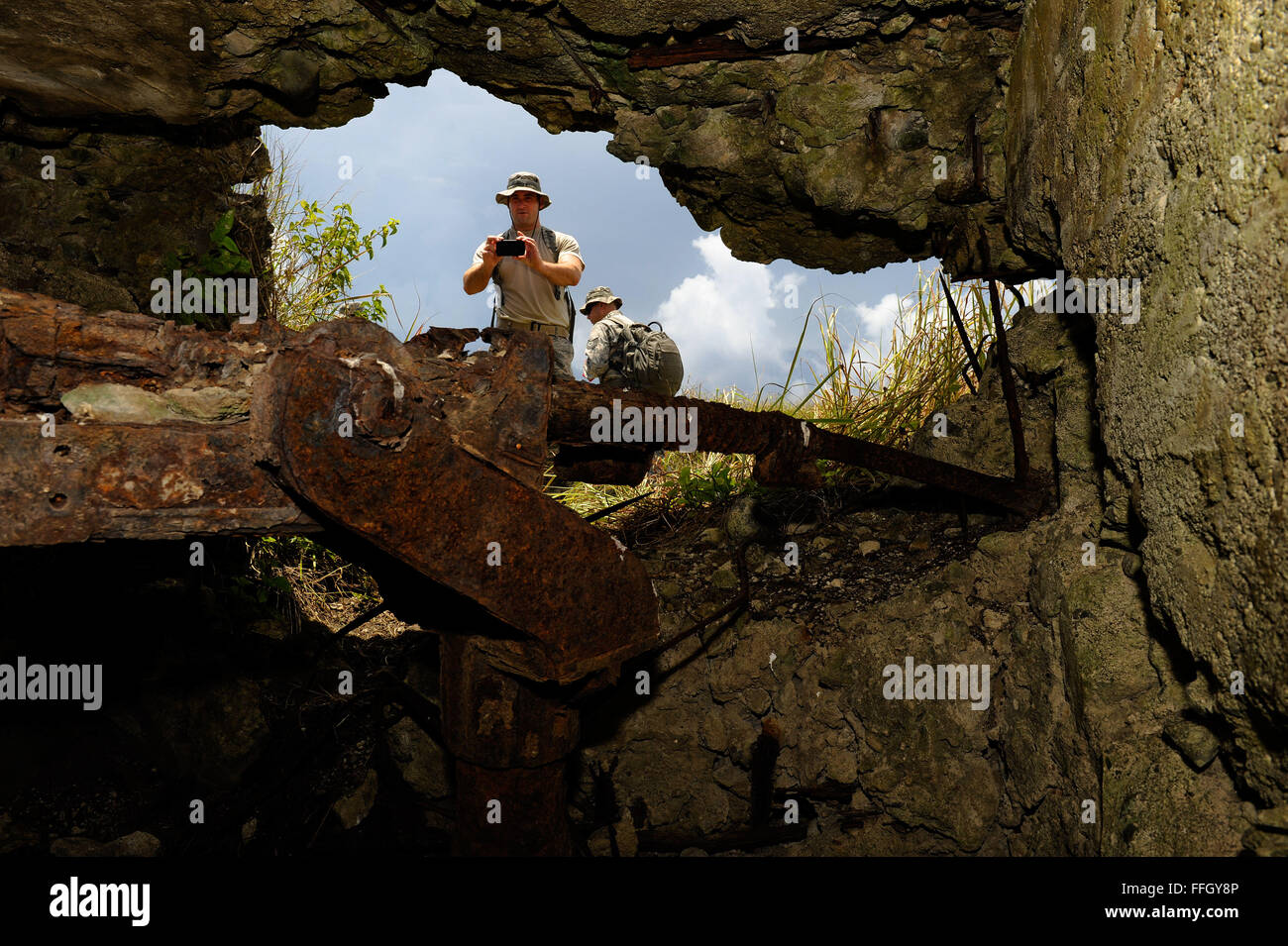 An Airman takes a photo of a destroyed Japanese pillbox. Though the