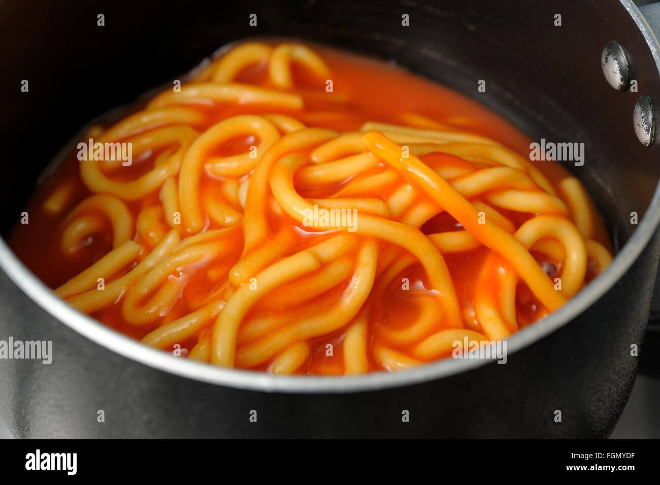 Heinz Spaghetti in tomato sauce in a black pan ready to heat up Stock