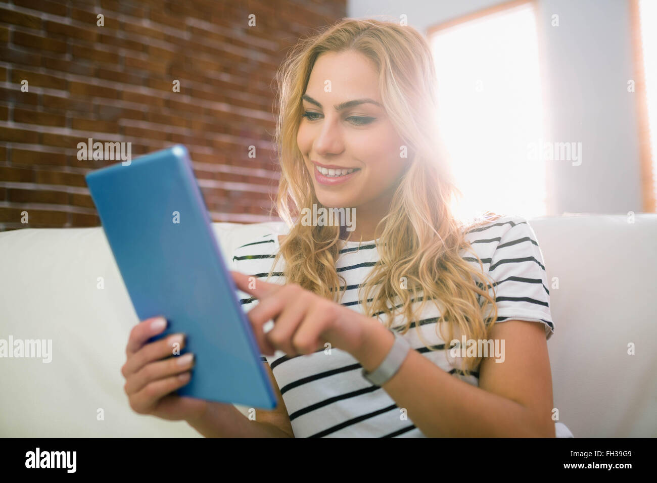 Pretty Blonde Using Tablet On Couch Stock Photo Alamy