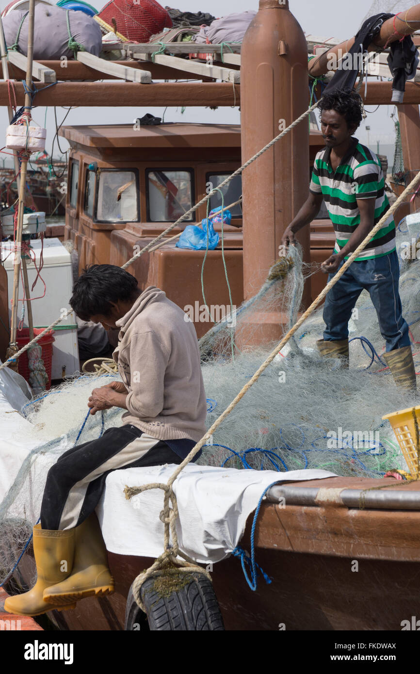 Two Fishermen Tend Nets On A Boat In Kuwait Stock Photo Alamy