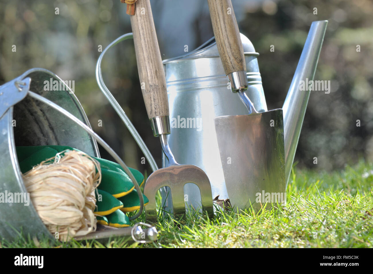gardening accessories and tools planted in green grass Stock Photo