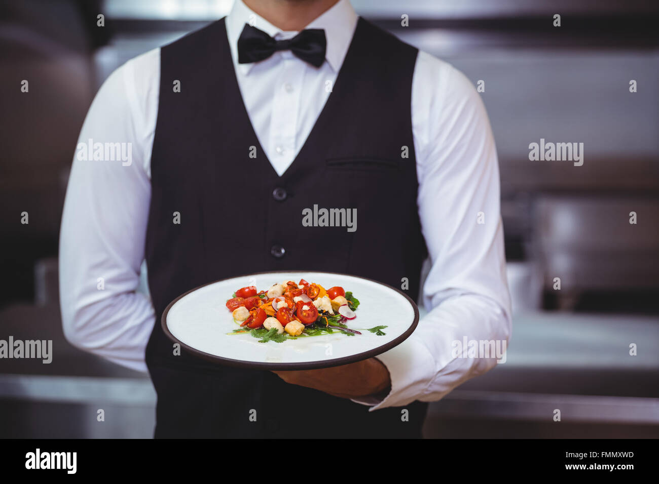 Handsome waiter holding a plate Stock Photo, Royalty Free Image