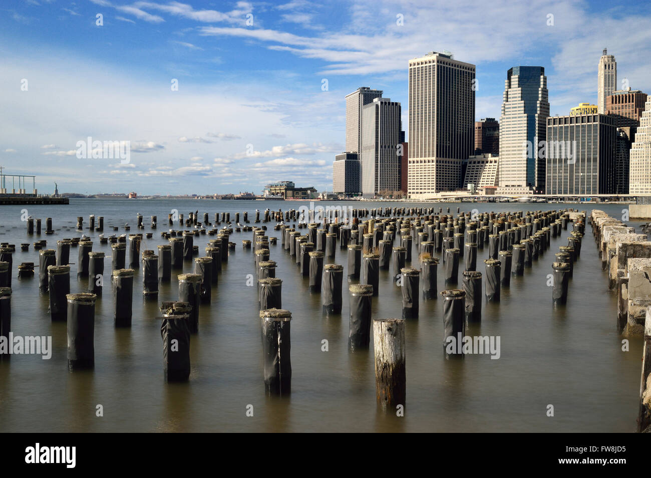 Old pier pylons and Downtown Manhattan, New York City Stock Photo