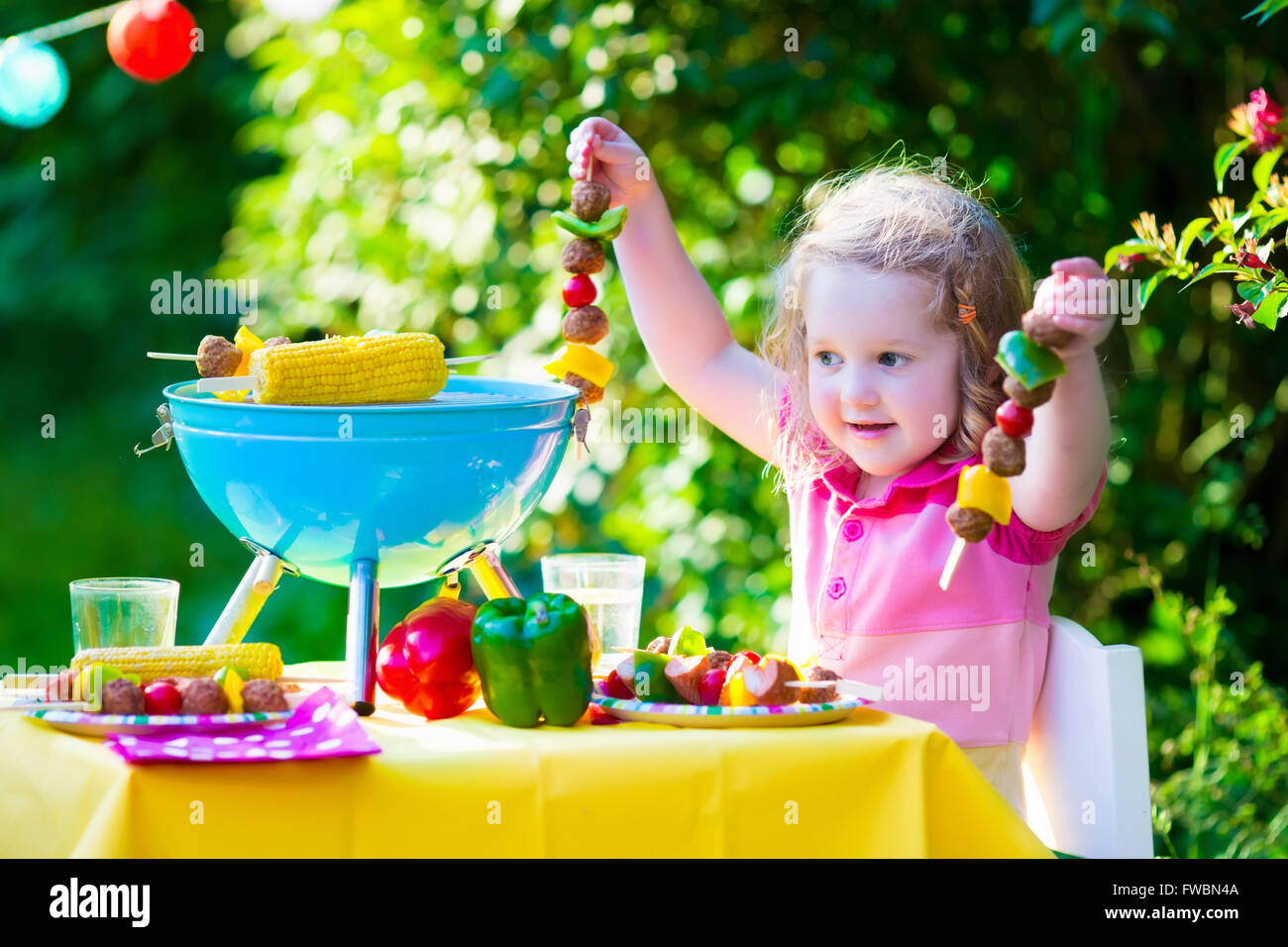 Children grilling meat. Family camping and enjoying BBQ. Little girl