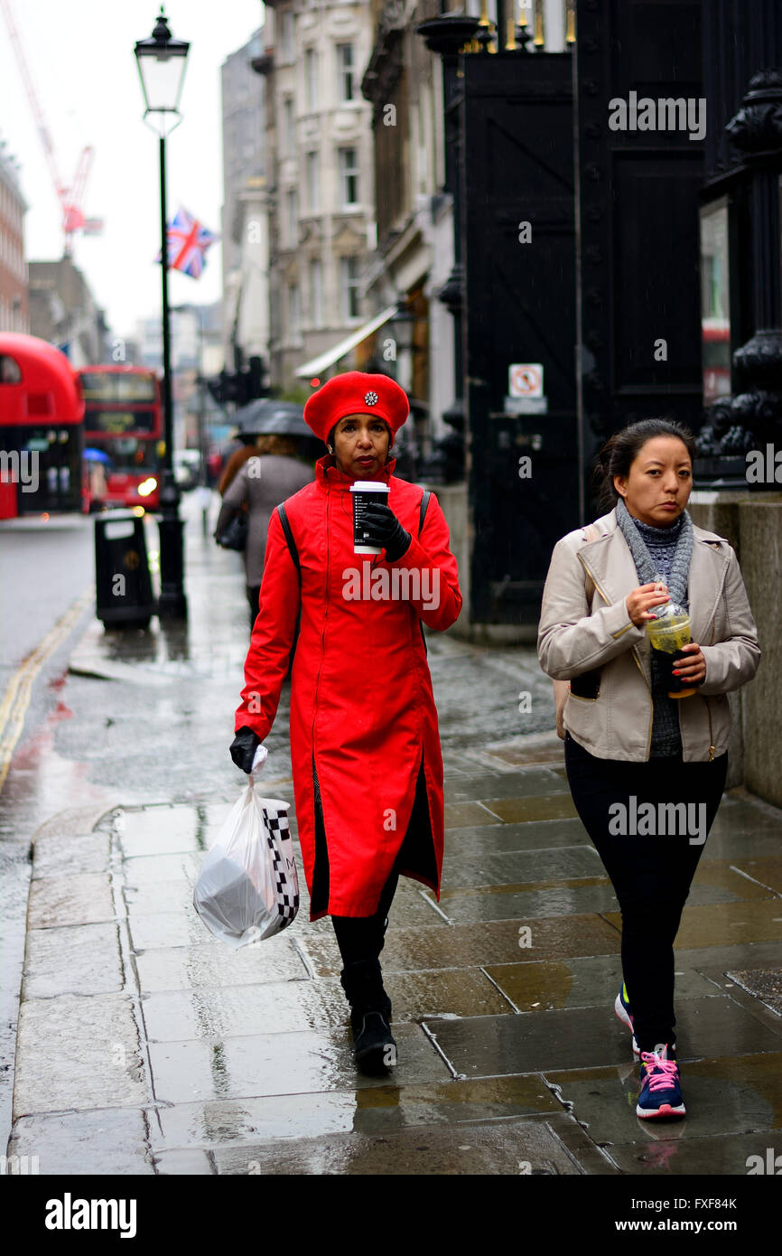 woman in red coat and hat with coffee walking in the rain Stock ...