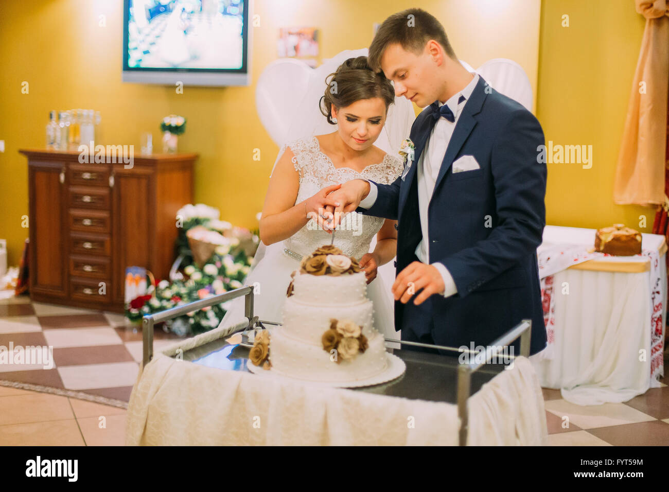 beautiful married couple cut the wedding cake decorated with beige beautiful married couple cut the wedding cake decorated with beige