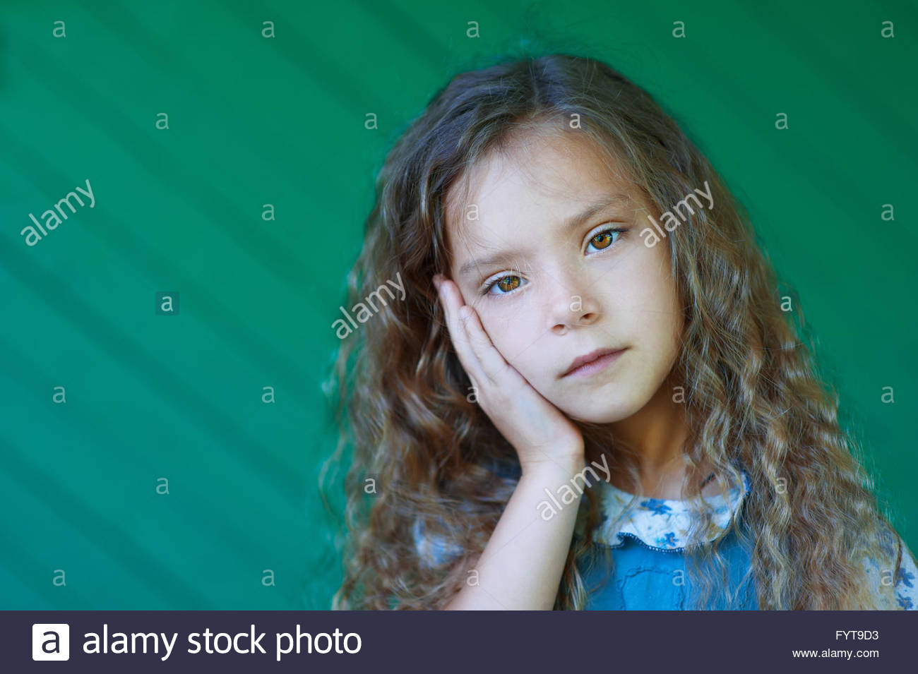 Beautiful Sad Little Girl With Curly Hair Close Up Stock Photo