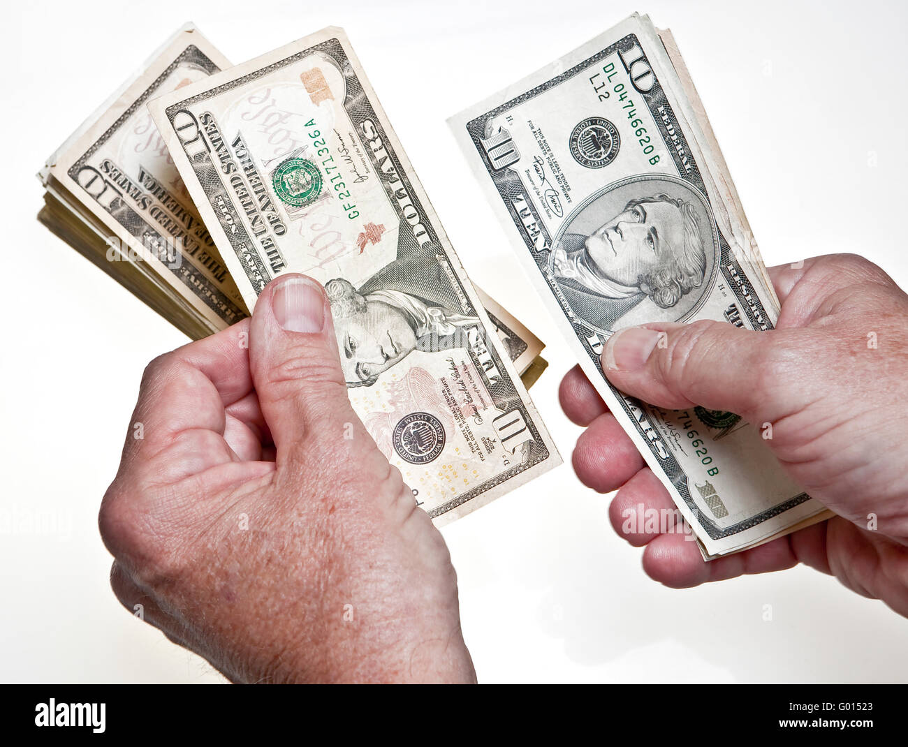 worksheet Counting Dollar Bills older mans hands counting ten dollar bills onto a stack on white background