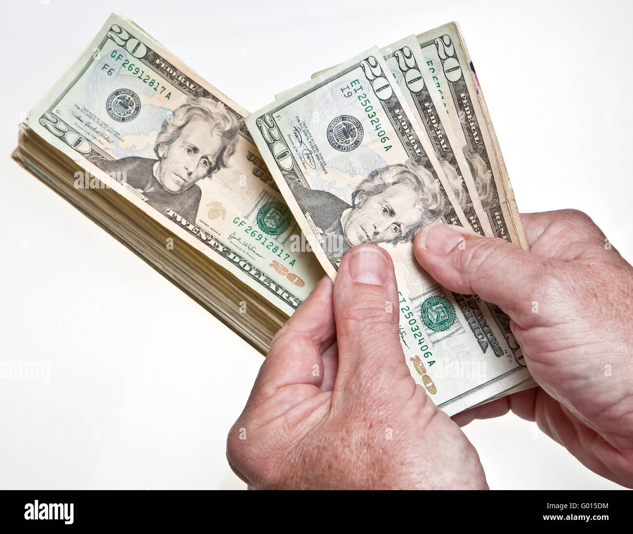 worksheet Counting Dollar Bills older mans hands counting twenty dollar bills onto a stack on white background