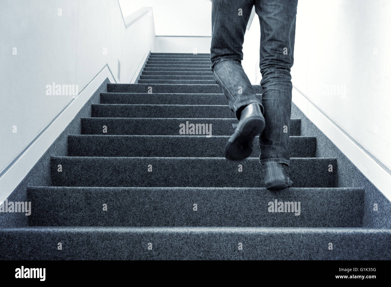 Man walking upstairs on staircase Stock Photo, Royalty Free Image