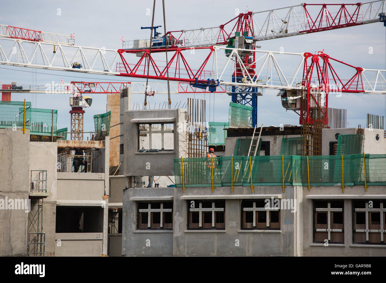 Tower Cranes Lifting Precast Concrete Blocks For Building Of HDB Houses