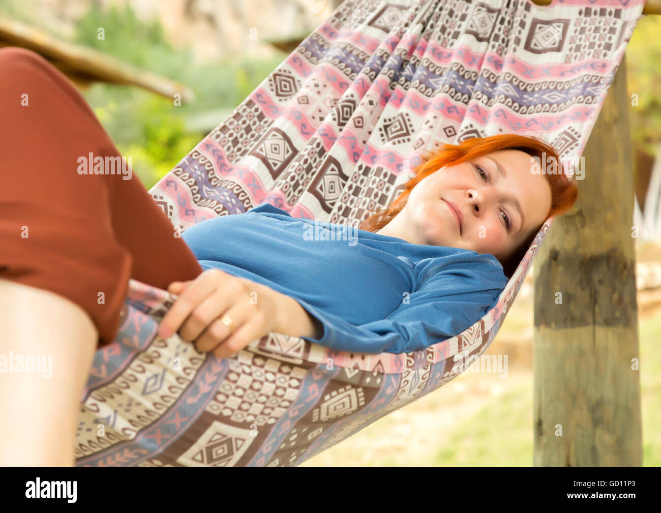 Woman Lying In Hammock At Patio Of Wooden Rural Cottage Stock Photo Alamy