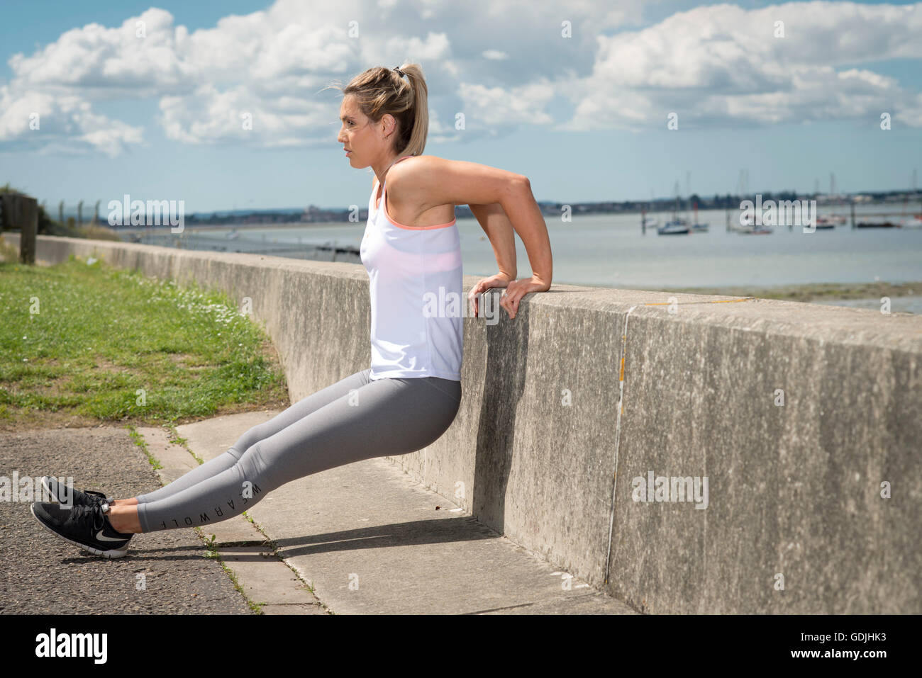 Fit Blonde Woman Doing A Back Press Ups On A Wall Stock Photo Alamy