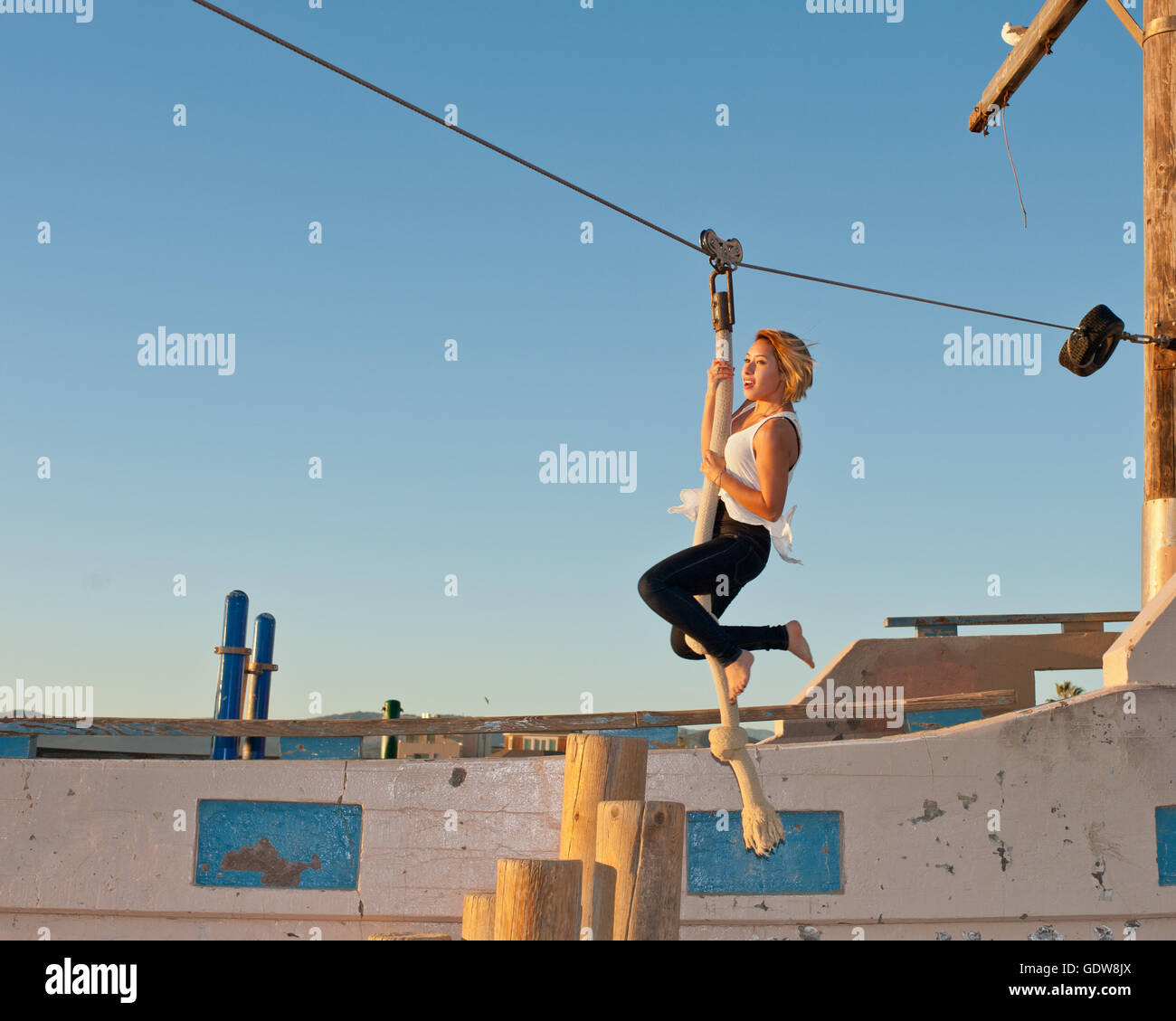 Teenage girl taking off on the beach zip line Stock Photo, Royalty Free