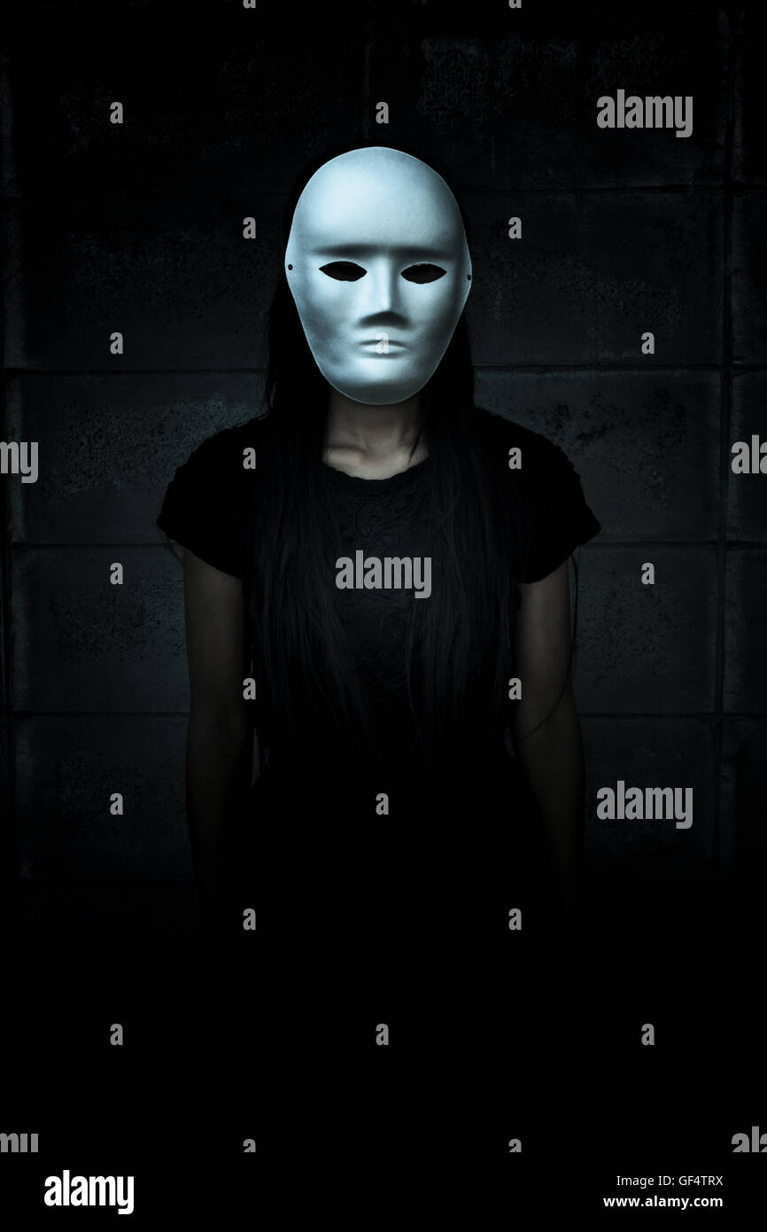 Mysterious woman in black dress wearing white mask,Scary background