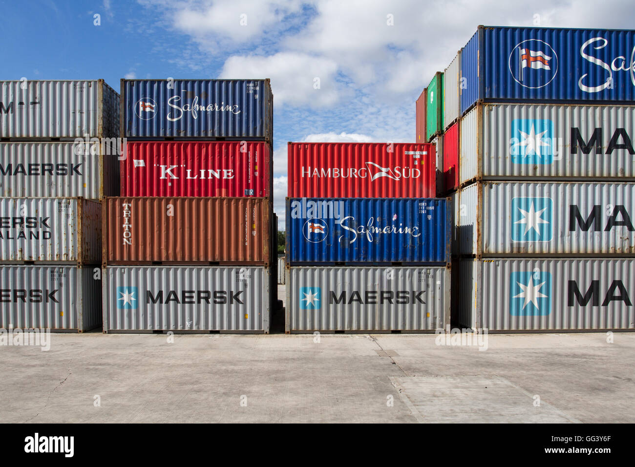 Cargo And Shipping Containers Stacked High Before Being Loaded Onto