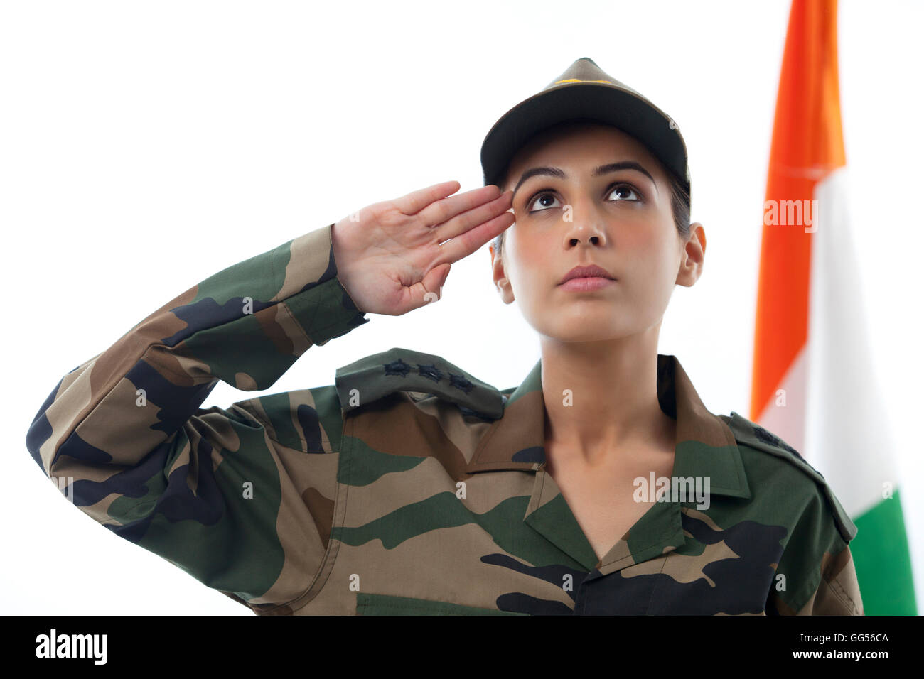 Female Soldier Saluting While Looking Up And Indian Flag In Background Female Soldier Saluting While Looking Up And Indian Flag In Background